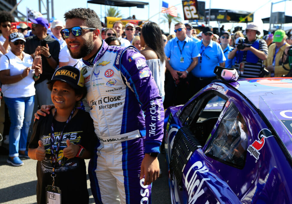 DAYTONA BEACH, FL - FEBRUARY 18:  Darrell Wallace Jr., driver of the #43 Click n' Close Chevrolet, poses with a fan prior to the Monster Energy NASCAR Cup Series 60th Annual Daytona 500 at Daytona International Speedway on February 18, 2018 in Daytona Beach, Florida.  (Photo by Daniel Shirey/Getty Images)