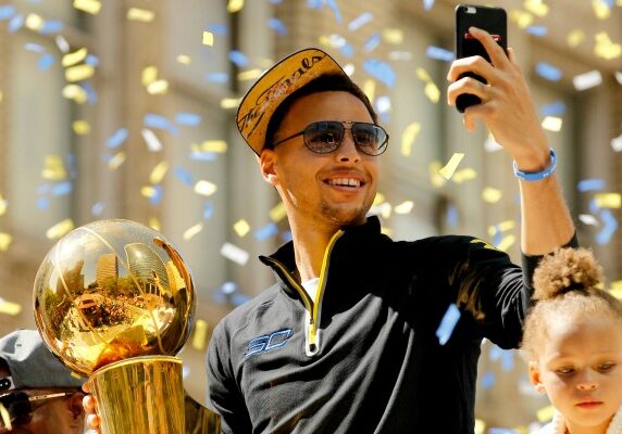 Jun 19, 2015; Oakland, CA, USA; Golden State Warriors guard Stephen Curry takes a photo with his cellular phone during the Golden State Warriors 2015 championship celebration in downtown Oakland. Mandatory Credit: Cary Edmondson-USA TODAY Sports